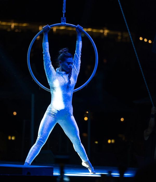 Man performing a strength and balance exercise in a dark room.